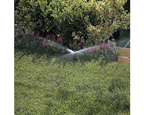 Aspersor udând gazonul în grădină