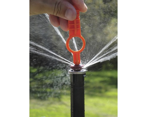 Aspersor de irigare în funcțiune cu cheie de reglare.