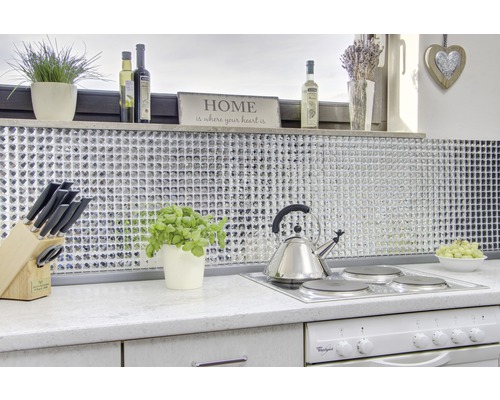 Bucătărie luminoasă cu plăci de mozaic, plită, ceainic și elemente decorative.