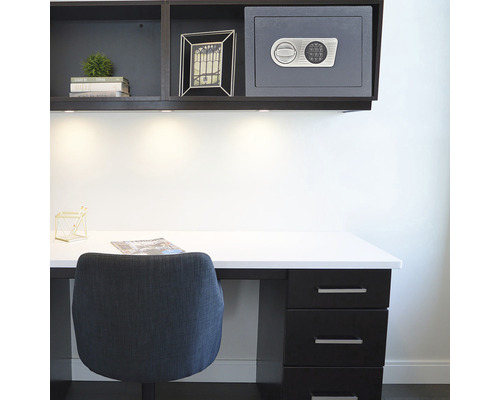 Scenă dintr-un birou cu un birou, un scaun și o seif în raft.