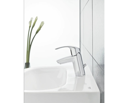 Baterie de chiuvetă pe o chiuvetă cu o vază de flori