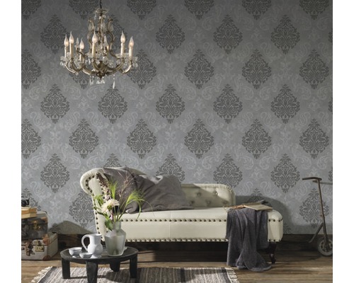 Cameră decorativă cu o canapea în fața unui tapet cu model și o atmosferă vintage.