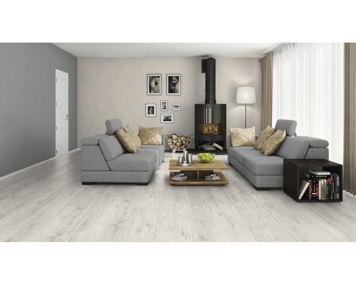 Cameră de zi luminoasă cu podea laminată, canapea gri și șemineu.