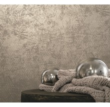 Tapet cu model structurat și două bile decorative pe un taburet