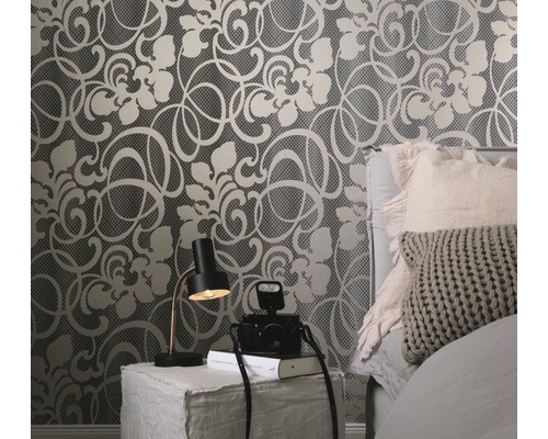 Dormitor decorativ cu tapet cu model floral, lampă de noptieră și cameră foto