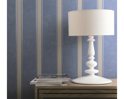 Tapetă decorativă cu model cu dungi în spatele unei lămpi de masă și a revistelor