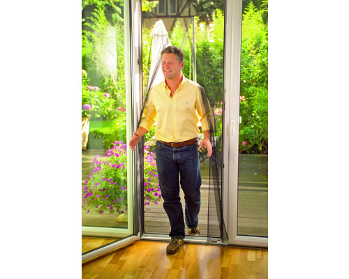 Bărbat care trece printr-o ușă cu plasă de țânțari.