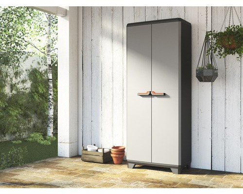 Dulap de grădină din plastic cu două uși în fața unui perete de lemn