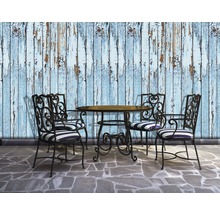 Scenă cu masă de grădină, patru scaune și un perete cu vopsea exfoliată