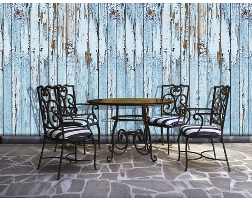 Scenă cu masă de grădină, patru scaune și un perete cu vopsea exfoliată