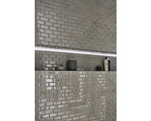 Design de perete cu plăci dreptunghiulare lucioase și raft integrat cu iluminare în baie