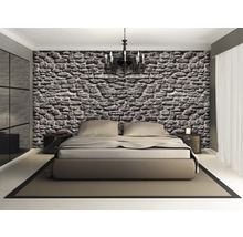 Dormitor cu tapet cu pereți de piatră, pat dublu, noptiere și candelabru