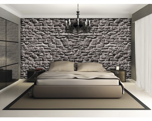 Dormitor cu tapet cu pereți de piatră, pat dublu, noptiere și candelabru