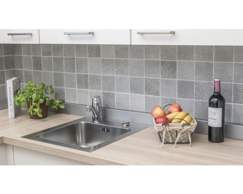 Chiuvetă de bucătărie cu robinet pe un blat cu perete din spate cu gresie