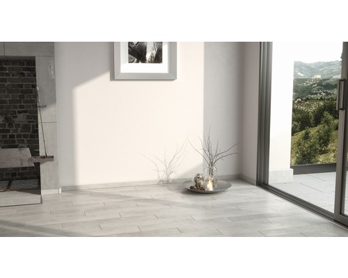 Cameră luminoasă cu pardoseală cu gresie, decorată cu plante și lumânări