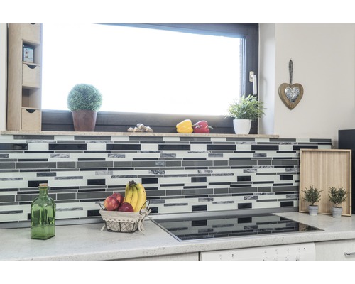 Scenă de bucătărie cu plăci de mozaic, fructe și decorațiuni în fața unei ferestre.