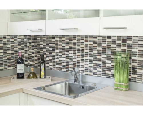 Chiuvetă de bucătărie cu baterie, faianță mozaic și decorațiuni pe un blat.