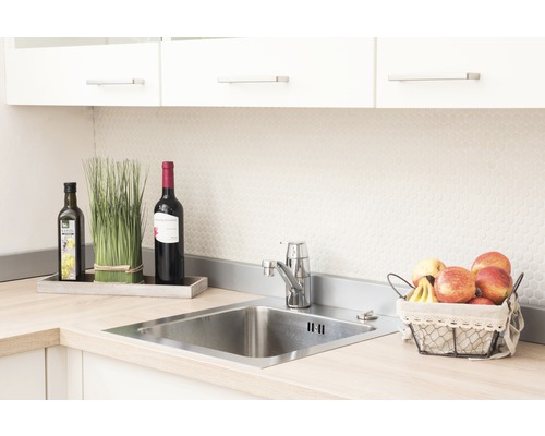 Chiuvetă de bucătărie din oțel inoxidabil cu robinet, înconjurată de decorațiuni și alimente.