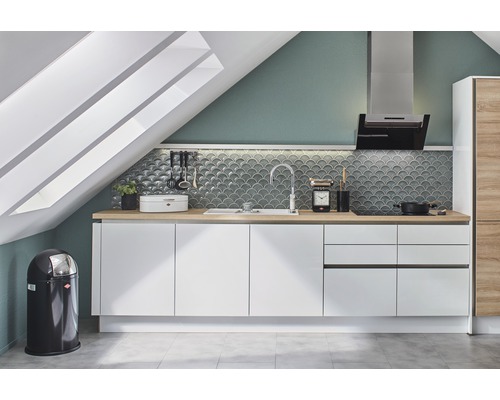 Bucătărie într-o mansardă cu dulapuri albe și blaturi din lemn