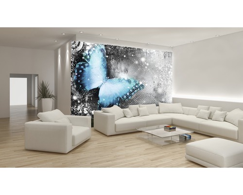 Living cu fototapet cu motiv de fluture, mobilier deschis la culoare și podea din lemn.