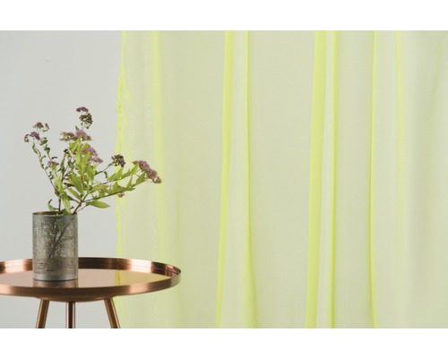 Scenă decorativă cu un buchet de flori într-o vază pe o masă și o perdea transparentă în fundal