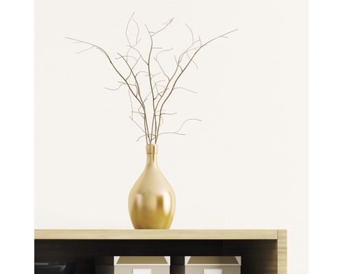 Vază decorativă de culoare aurie cu crengi pe un raft.