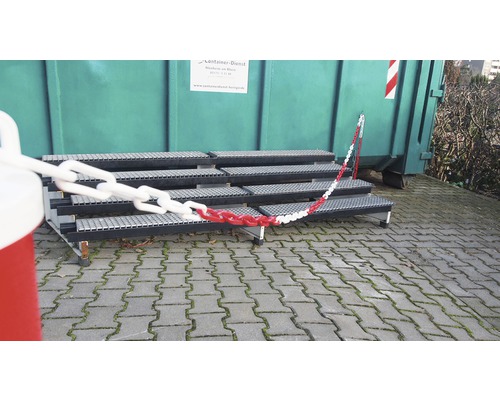 Scară de acces cu lanț roșu-alb în fața containerului