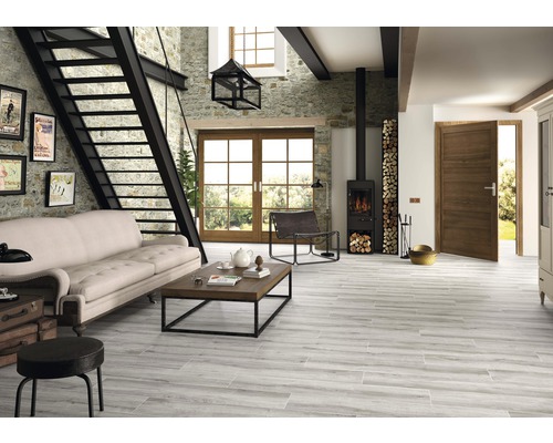 Cameră de zi cu canapea, șemineu, scară și gresie cu aspect de lemn