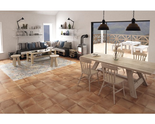 Cameră de zi luminoasă cu zonă de relaxare, masă și șemineu pe podea cu gresie.