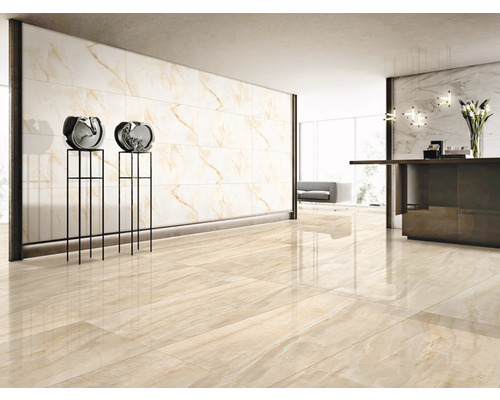 Cameră luminoasă cu gresie și faianță cu aspect de marmură, două obiecte decorative pe piedestale și o recepție