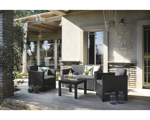 Terasa cu grup de ședere format din mobilier din ratan, format dintr-o canapea, fotolii și o masă