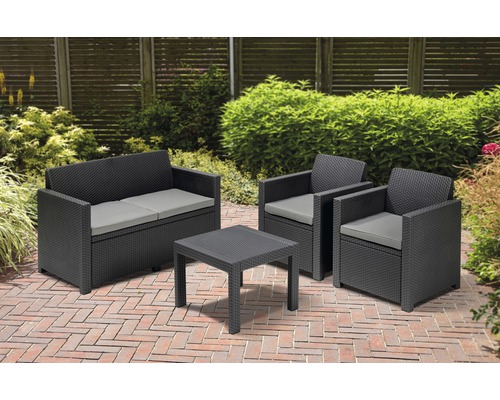 Set de mobilier de grădină cu canapea, două fotolii și o masă pe o terasă.