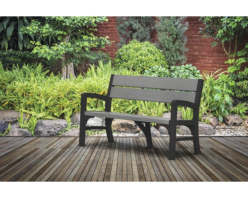 Bancă de grădină din plastic pe terasă de lemn în fața grădinii