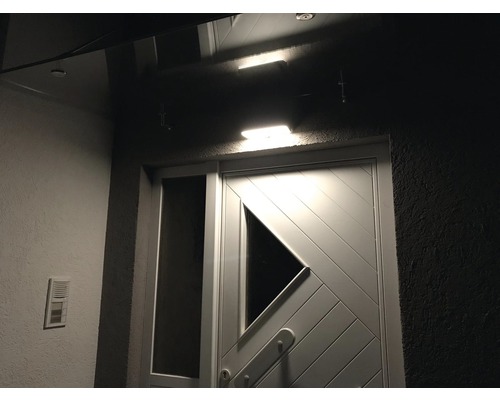 Zonă de intrare în casă iluminată cu ușă și sonerie