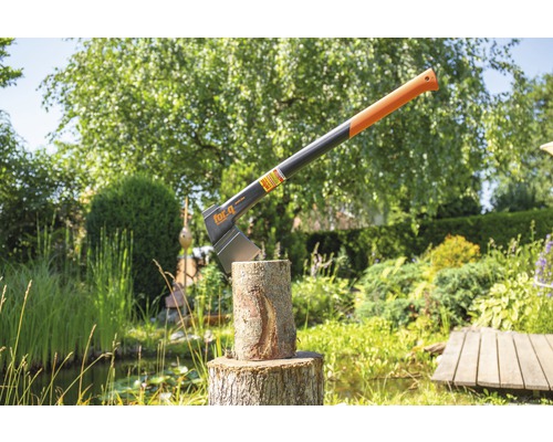 Topor de despicat în trunchi de copac în grădină
