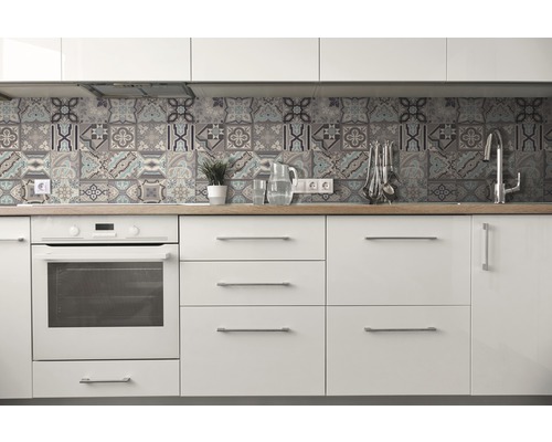 Bucătărie luminoasă cu dulapuri albe, blat de lucru din lemn și faianță cu design patchwork