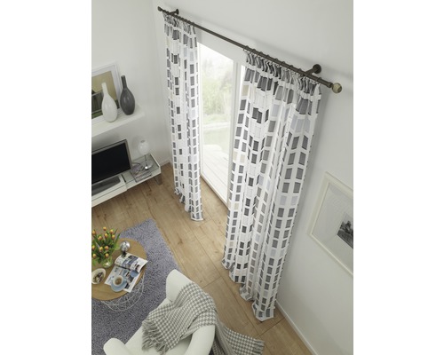 Living cu perdele cu model geometric în fața unei ferestre