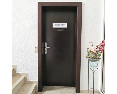 O ușă întunecată cu o fantă pentru scrisori și un semn Introduceți formularele aici