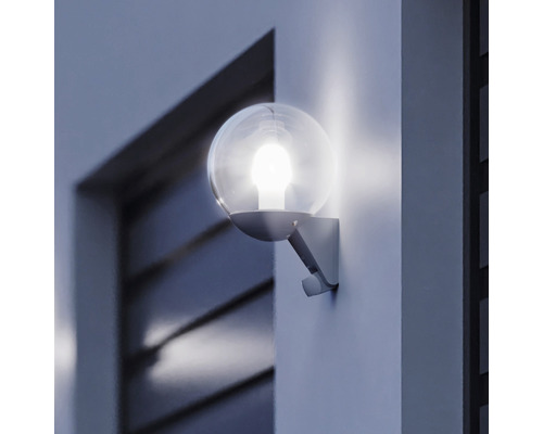 Lumină sferică de exterior aprinsă pe un perete de casă
