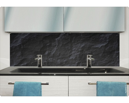 Baie modernă cu fundal din piatră neagră, chiuvete și prosoape