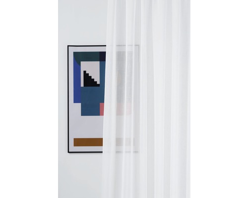 Cortină voal alb în fața unei imagini înrămate pe perete.