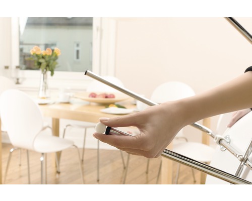 Femeie atașează un protector de picior de scaun de un picior de scaun metalic.