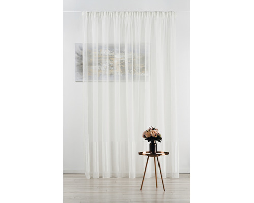 Draperie din voal în fața unui perete cu tablou și masă cu flori