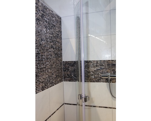 Detalii ale unei cabine de duș cu perete de sticlă și faianță în baie