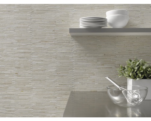 Decor de perete cu plăci de mozaic și ustensile de bucătărie pe un raft.