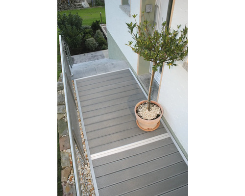 Terasa cu scânduri de terasă și jardinieră în fața intrării casei