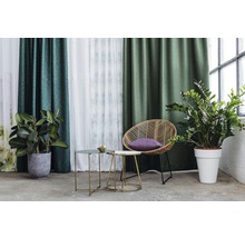 Interior decorativ cu perdele, plante și măsuțe laterale pentru o atmosferă plăcută.