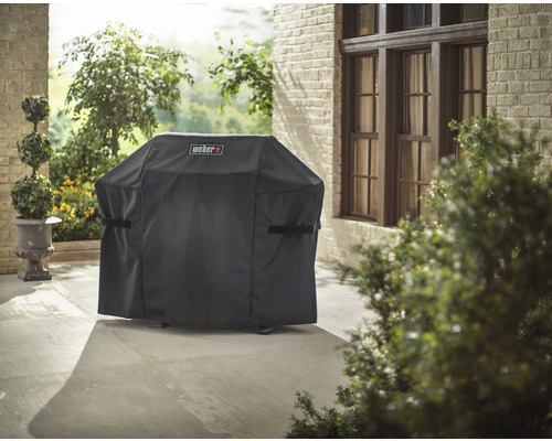 Husa de protecție pentru grătar cu logo Weber pe o terasă