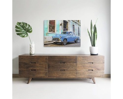 Decor de sufragerie cu comodă din lemn și tablou mural cu o mașină de epocă albastră