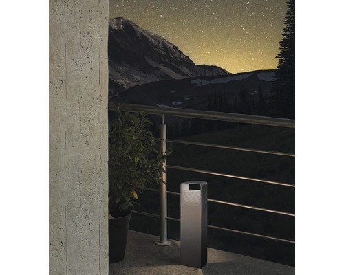 Scenă cu corp de iluminat exterior, plantă și balustradă pe fundal muntos